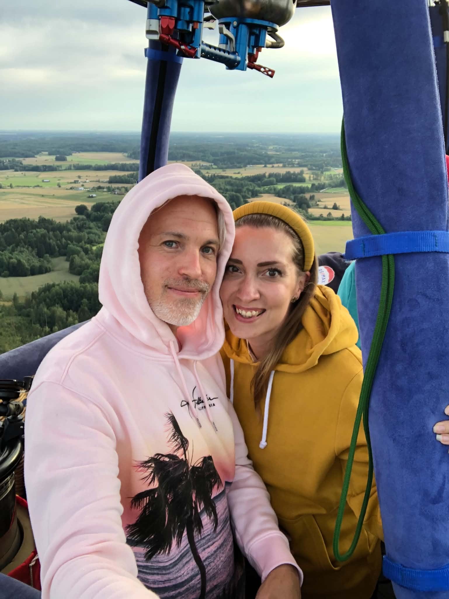 Media Kit Club's founders in a hot-air balloon basket above fields and forests